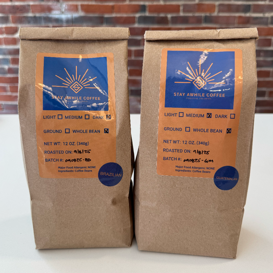 Two brown paper coffee bags with blue labels on a white surface.