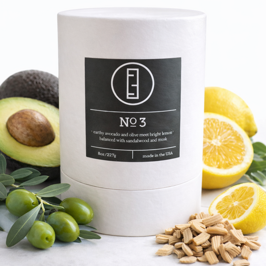 White candle labeled 'No. 3' with avocado, lemon, and olive on a white background
