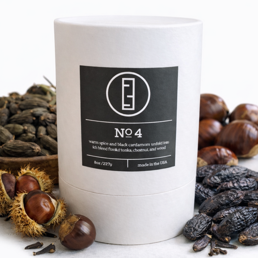 White cylindrical container with a black label featuring a logo and text, surrounded by chestnuts and dried fruits on a white background.