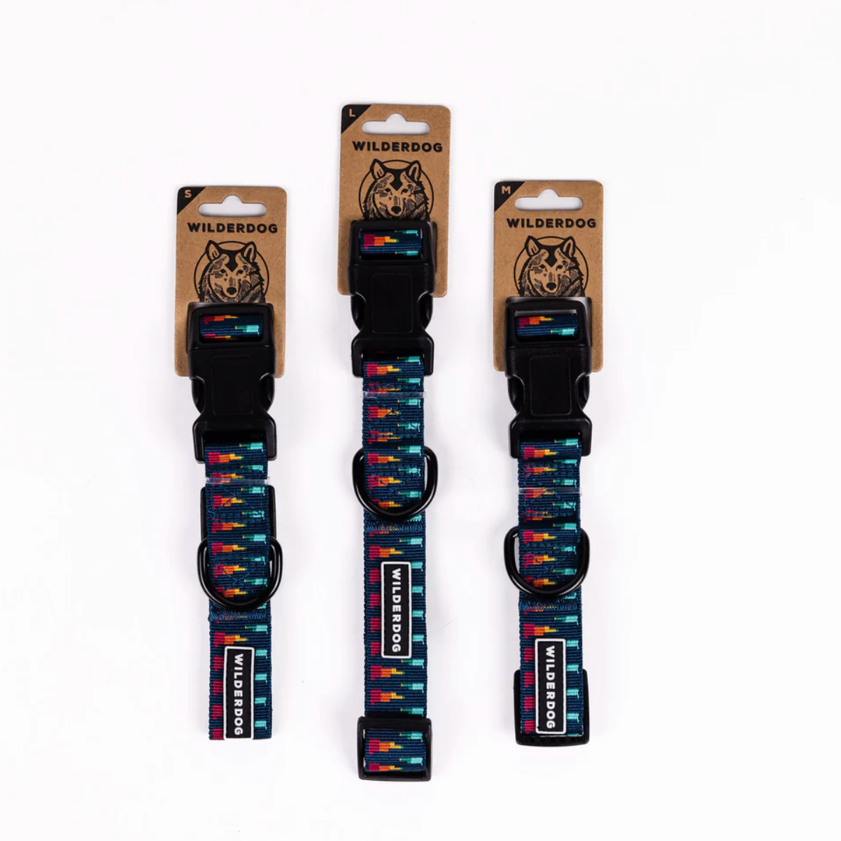 Three WilderDog dog collars with a colorful geometric pattern on a white background, each attached to its original cardboard packaging.