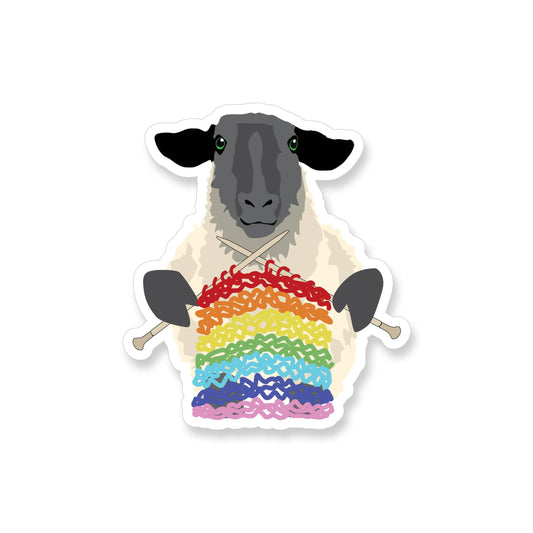 Sheep wearing a rainbow sweater with knitting needles on a white background