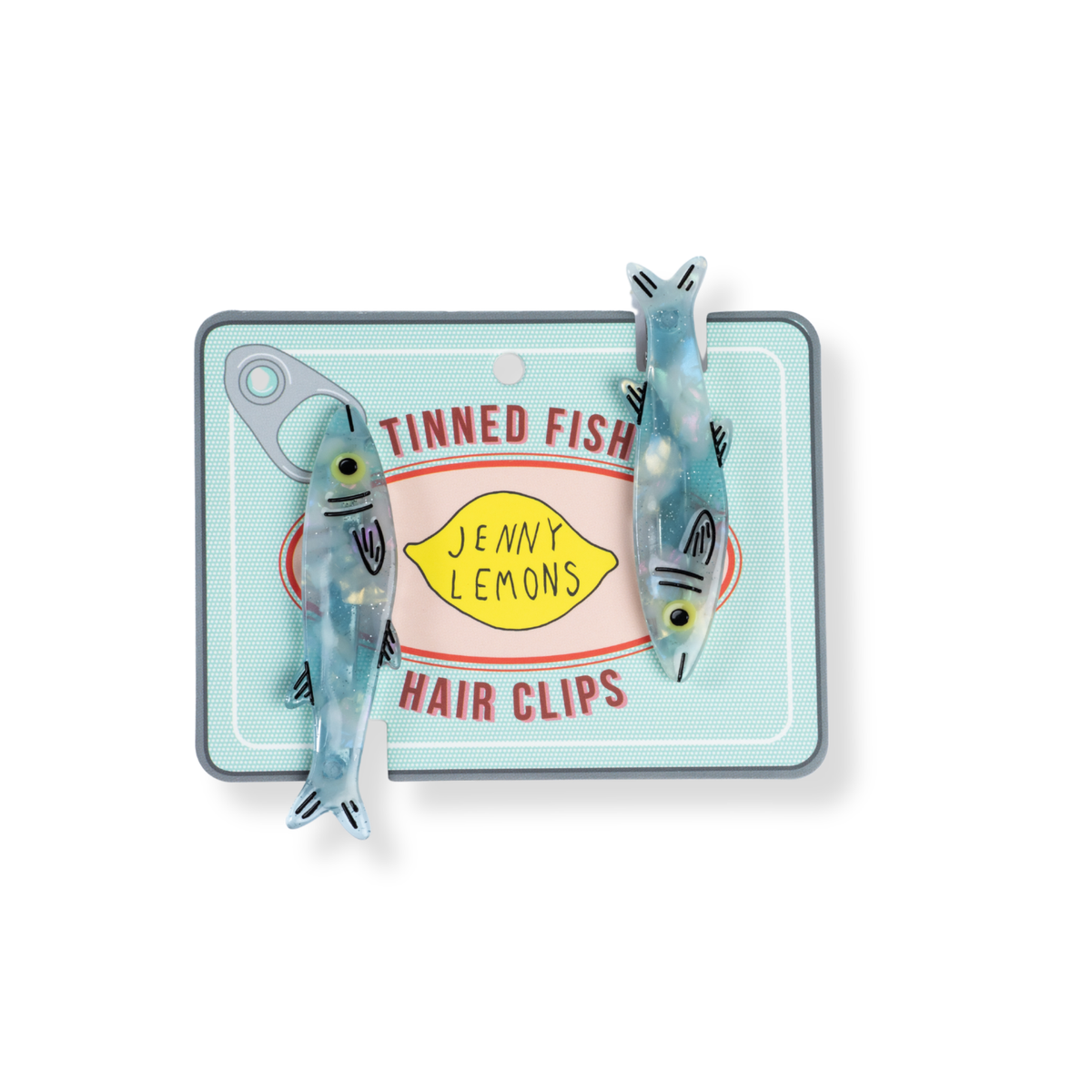 Two fish-shaped hair clips attached to a decorative backing card that reads 'Tinned Fish Hair Clips