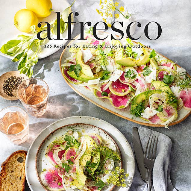 Cookbook cover featuring a salad dish with lemon, bread, and glasses on a table.