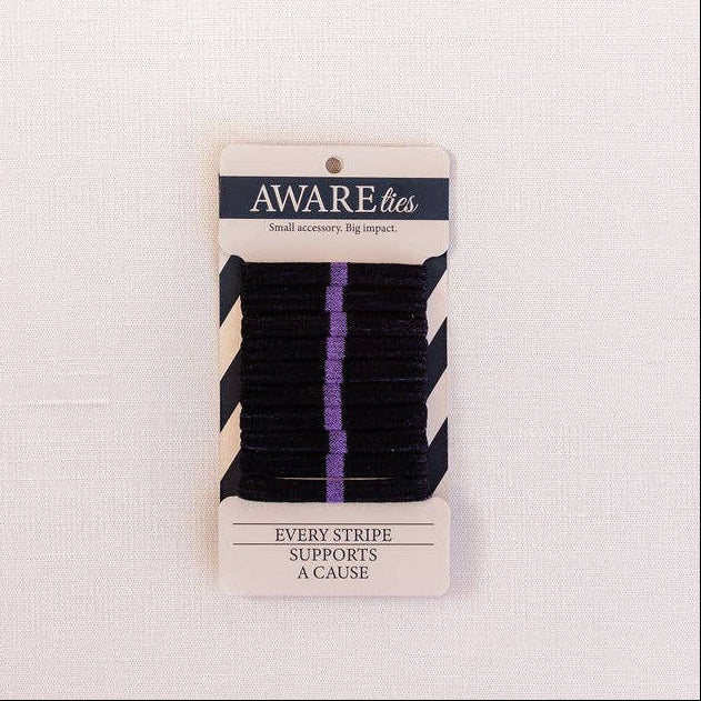 Pack of black hair ties with a 'Aware' brand label on a light pink background