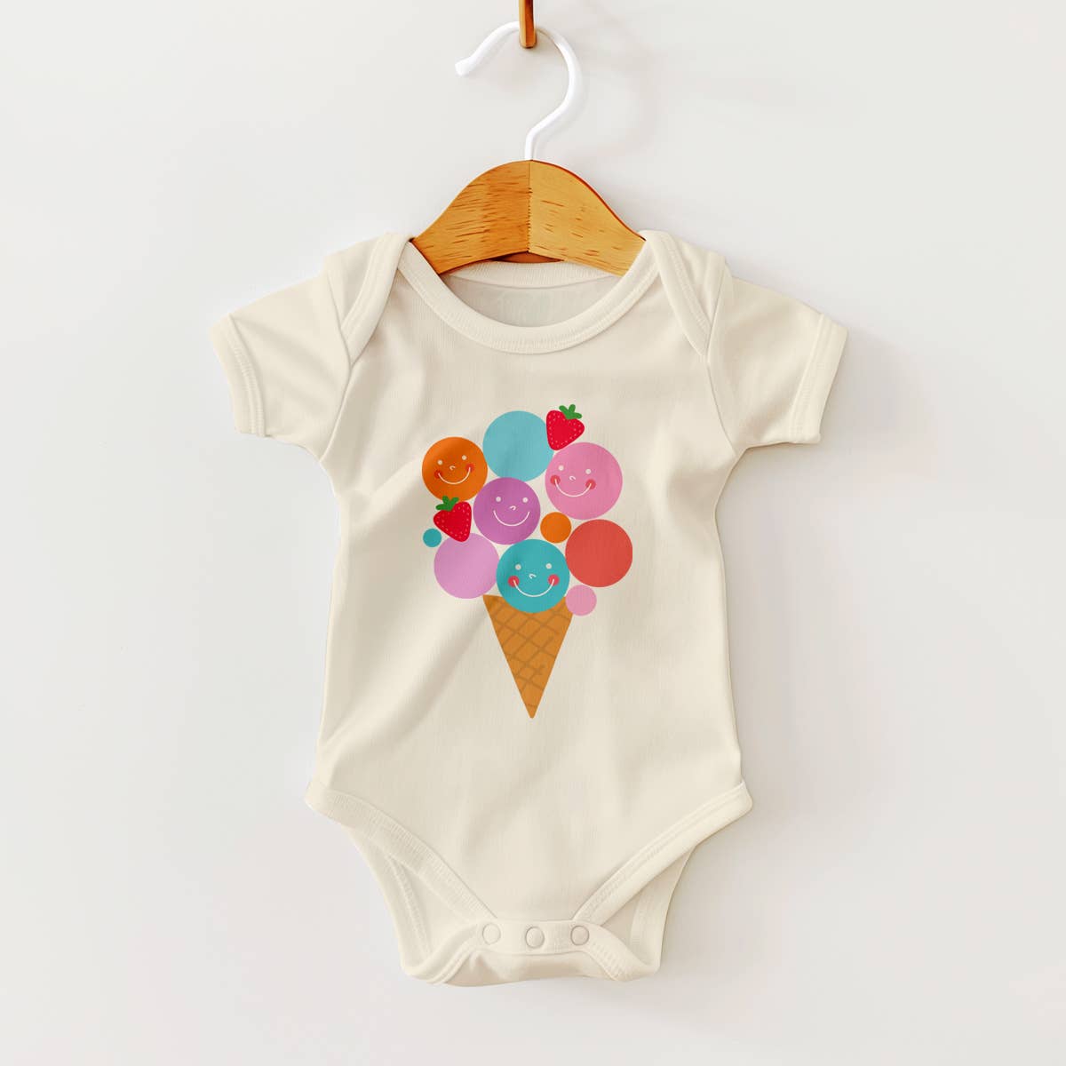 Baby onesie with ice cream cone design on a hanger against a white background