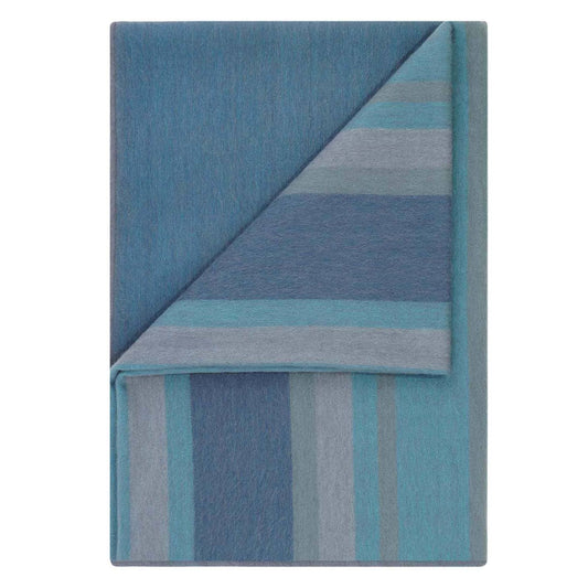 Folded blue and gray striped blanket on a white background