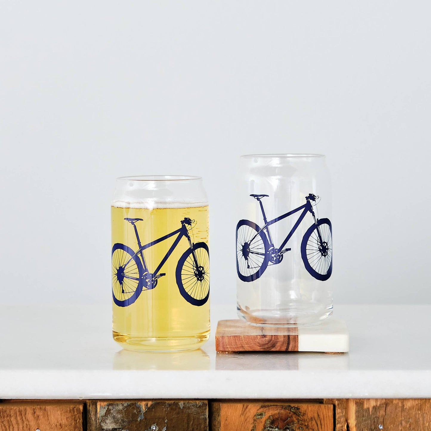 Two glasses with bicycle designs on a white background