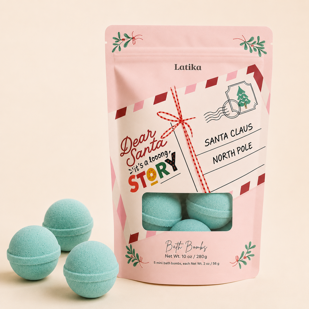 A pink stand-up pouch of Latika 'Dear Santa, It's a to-do! Story' bath bombs with a clear window showing three mint green round bath bombs, with two additional bath bombs placed in front on a light beige background.