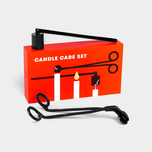 Candle care set with red box and black tools on a light gray background
