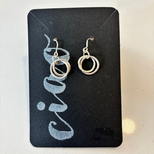 Pair of silver hoop earrings on a black card with a light background