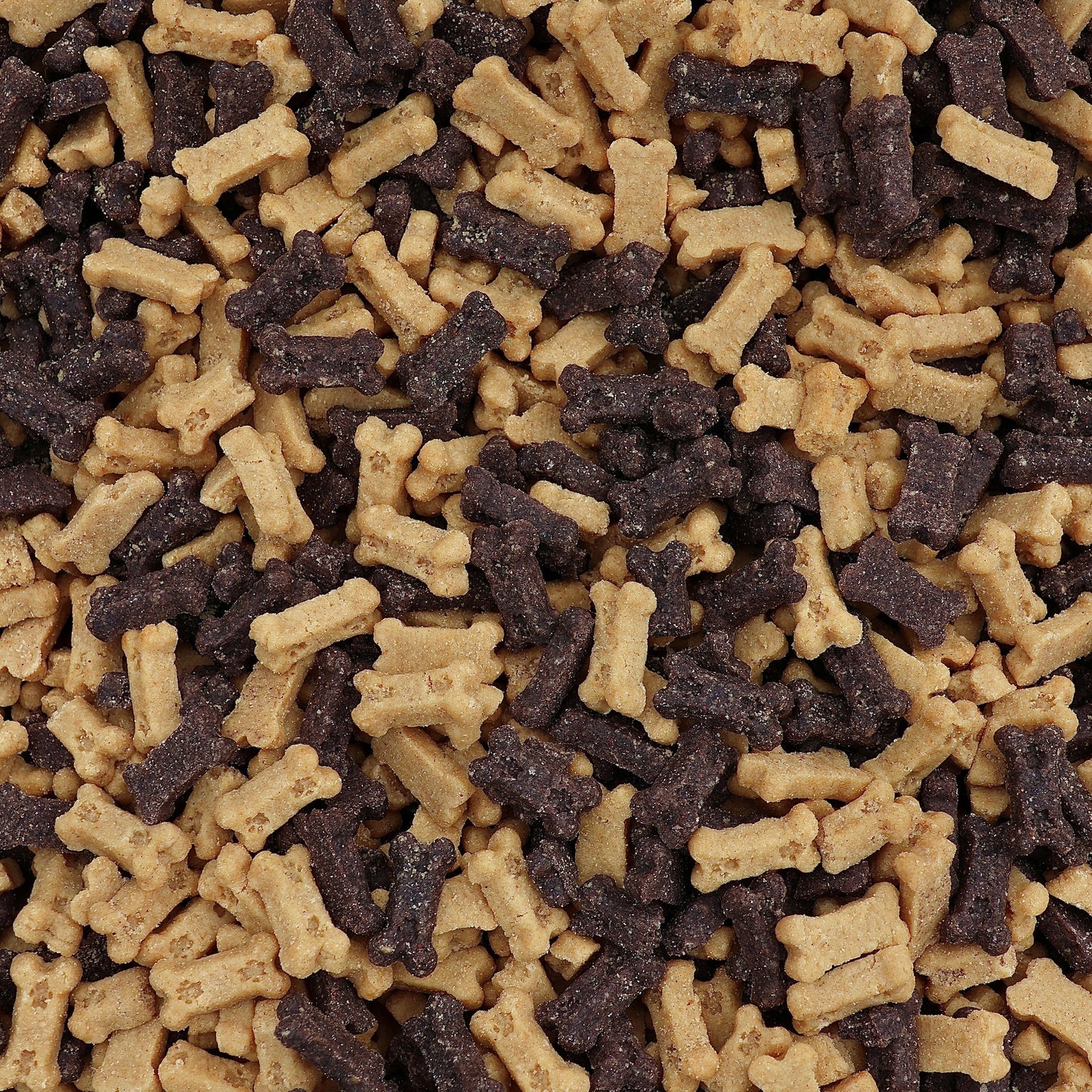 A close-up, top-down view of mixed dog treats shaped like bones, alternating between light tan and dark brown pieces.
