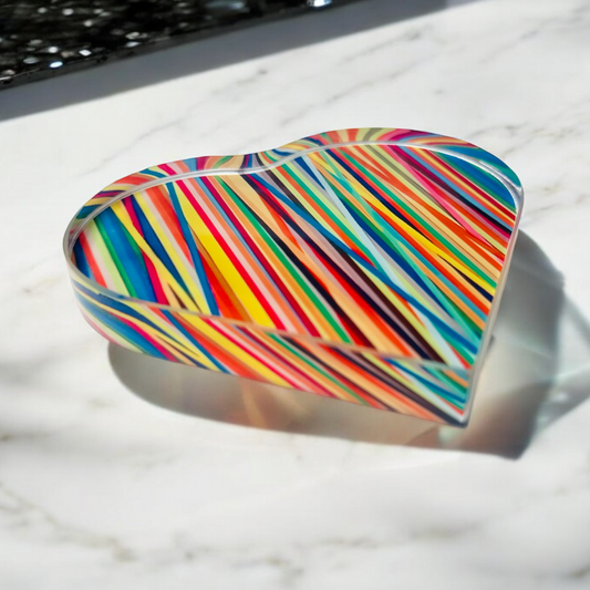 Colorful striped heart-shaped object on a marble surface