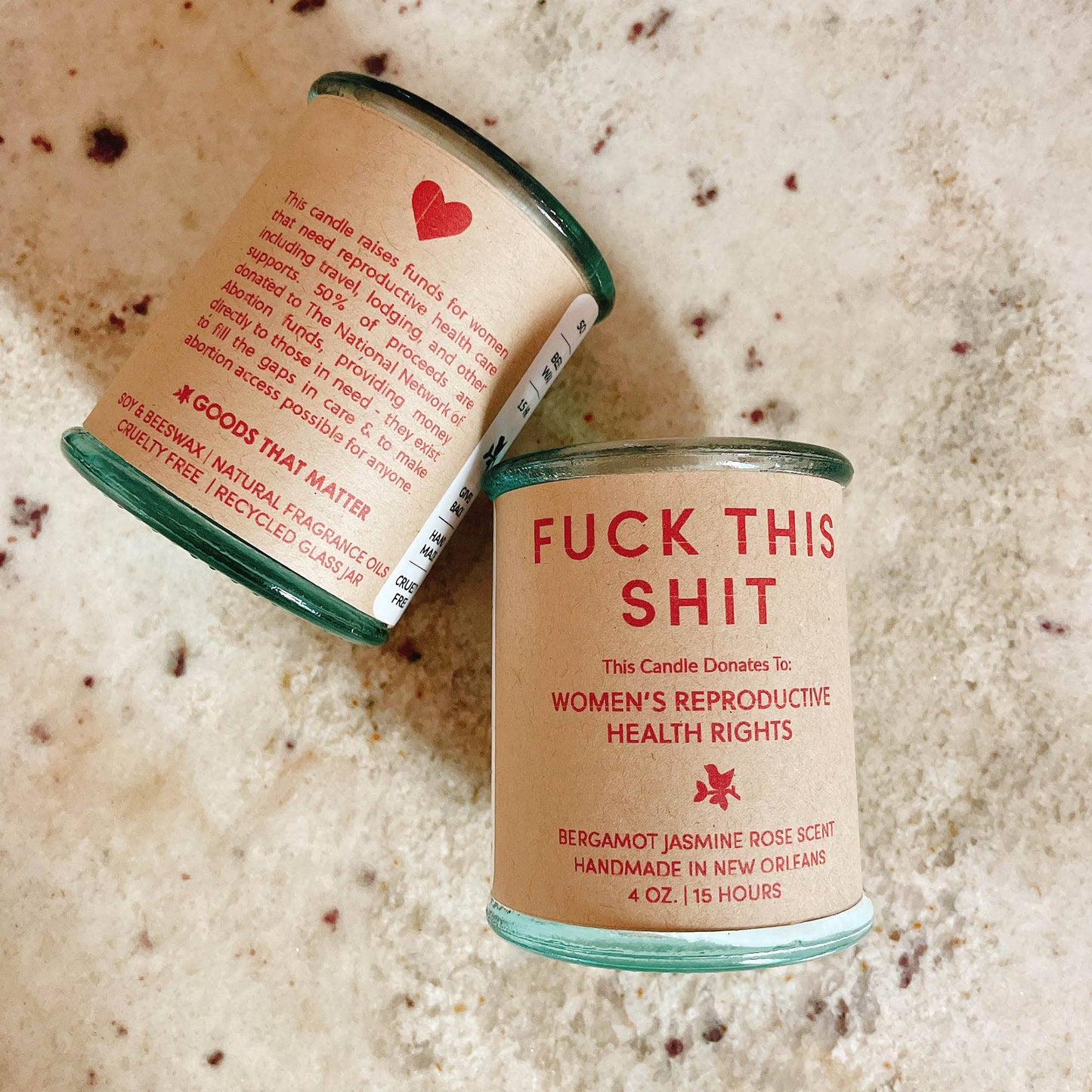 Candle with a message on the label against a textured beige background