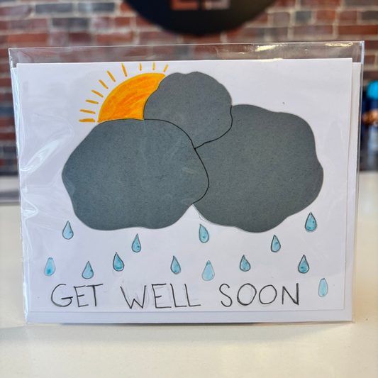 Card with weather illustrations and 'Get Well Soon' text on a plain background