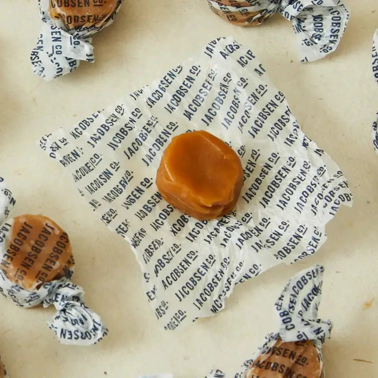 Caramel candies with paper wrappings on a textured surface