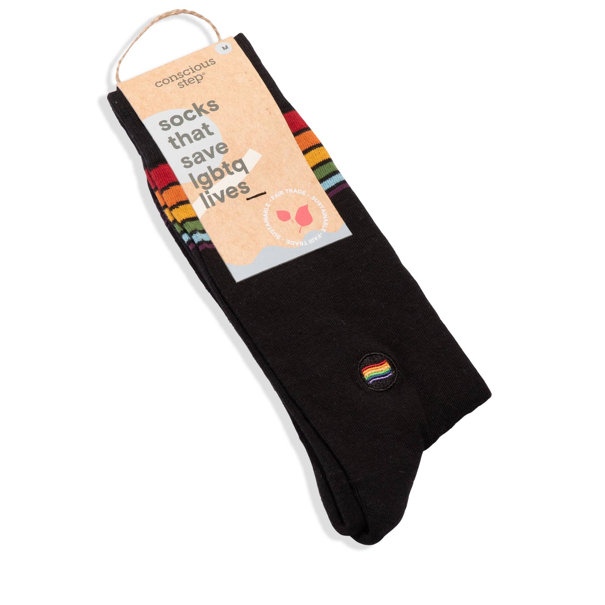 Black socks with a rainbow pride flag on packaging labeled 'conscious step' on a white background