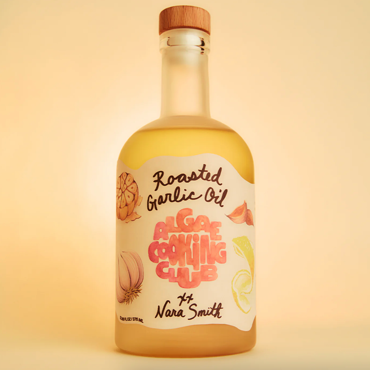 Bottle of roasted garlic oil with a wooden cap on a beige background