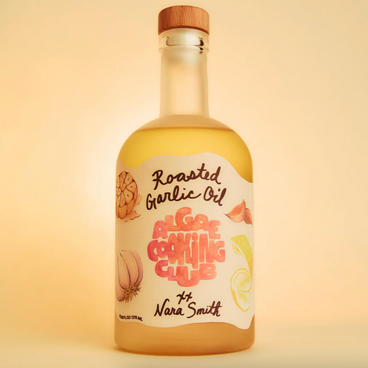 Bottle of roasted garlic oil with a wooden cap on a beige background