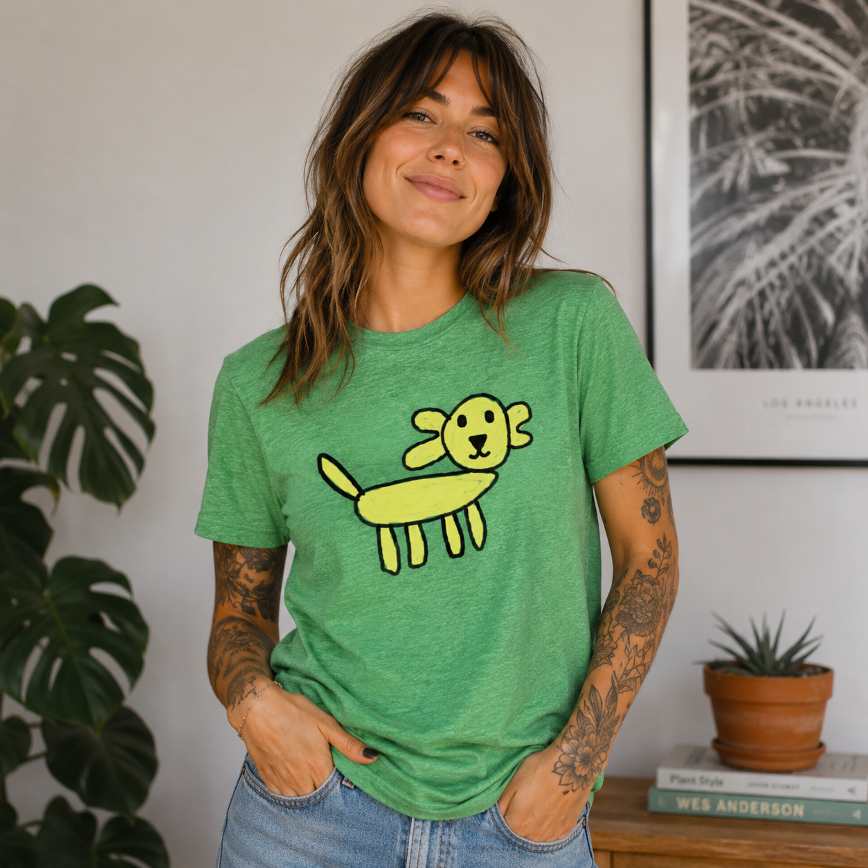 Woman wearing a green t-shirt with a yellow dog graphic, standing indoors.