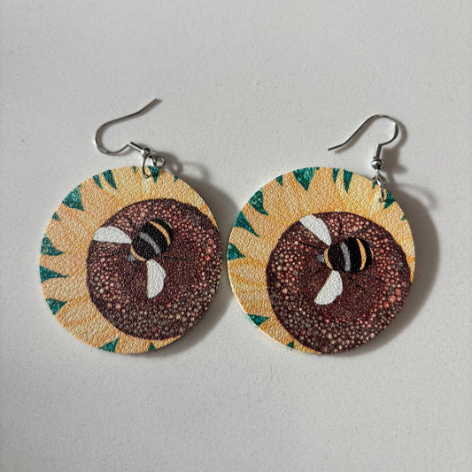 Pair of earrings with sunflower design on a gray background