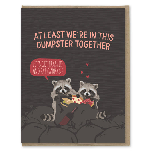 Card with two raccoons eating pizza, text 'At least we're in this dumpster together' and 'Let's get trash ed and eat garbage'.