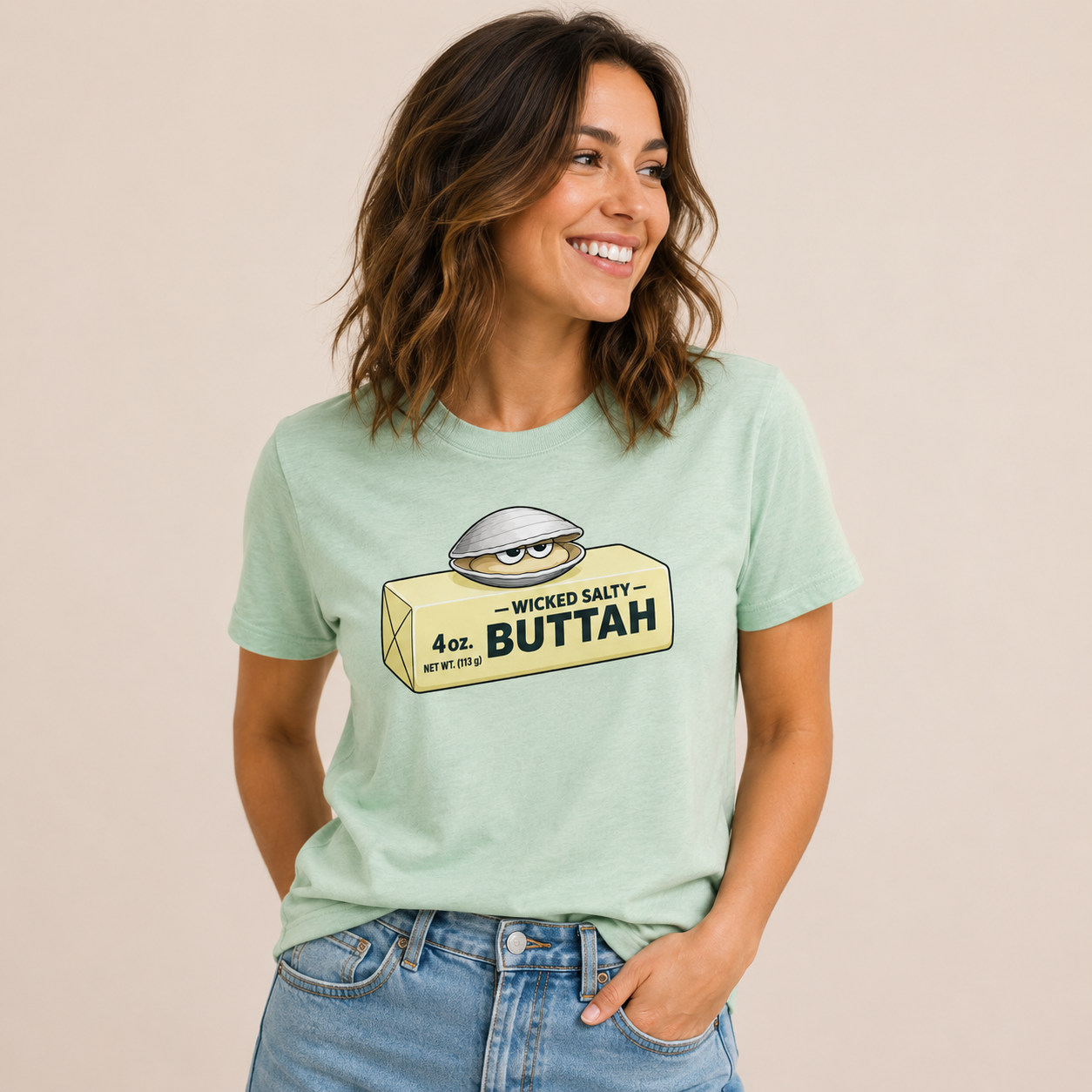 Woman wearing a light green t-shirt with a graphic design on a beige background