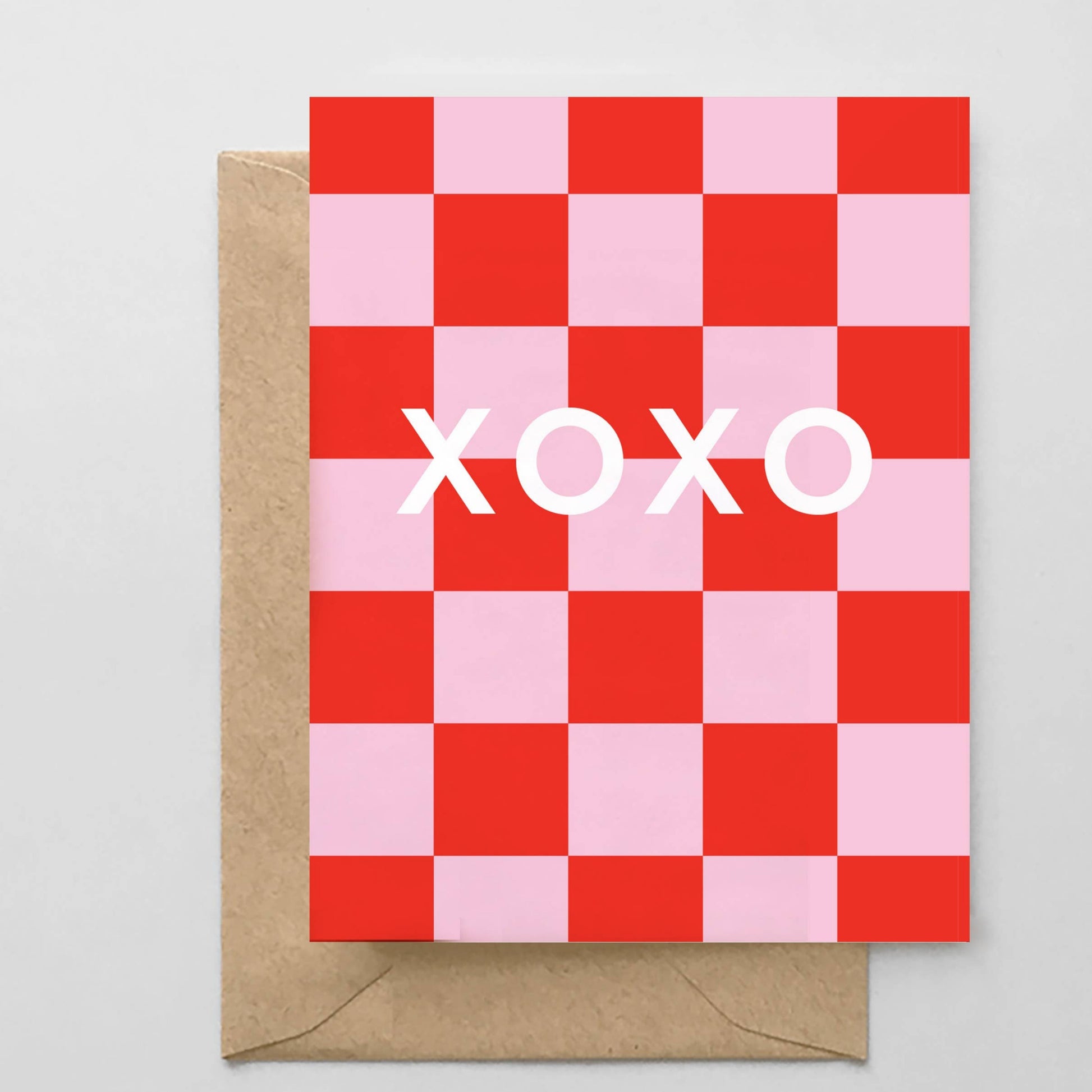 Checkered card with 'XOXO' text and brown envelope on gray background